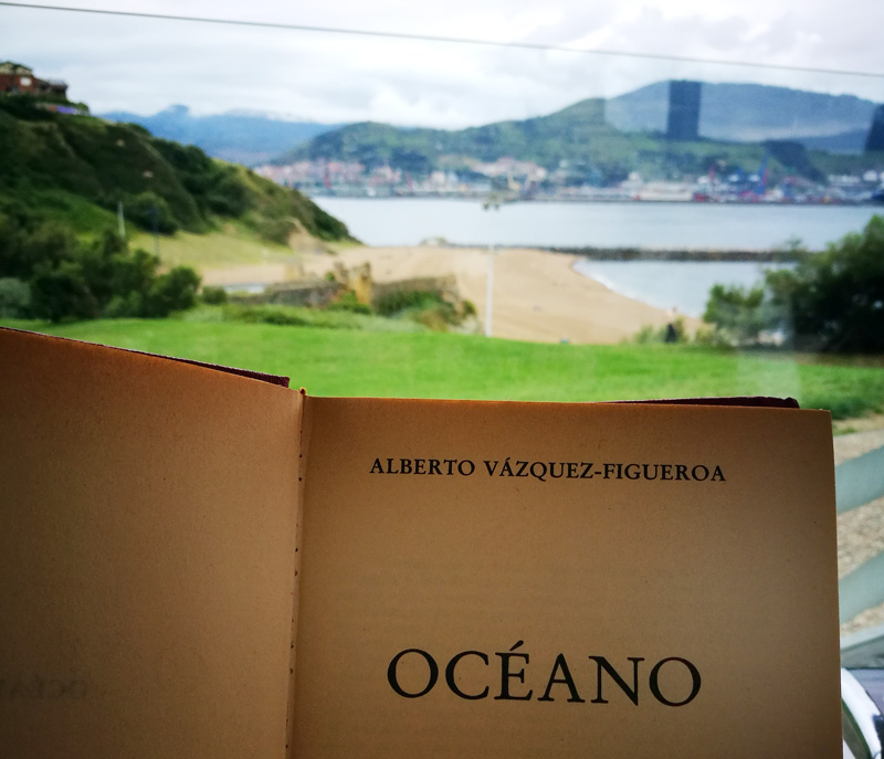 Imagen de la primera página del libro Océano de Alberto Vázquez Figueroa con un paisaje al fondo